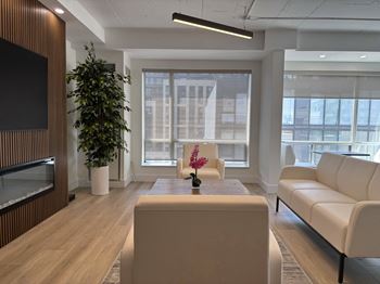 A modern living room with a flat screen TV and a large window.
